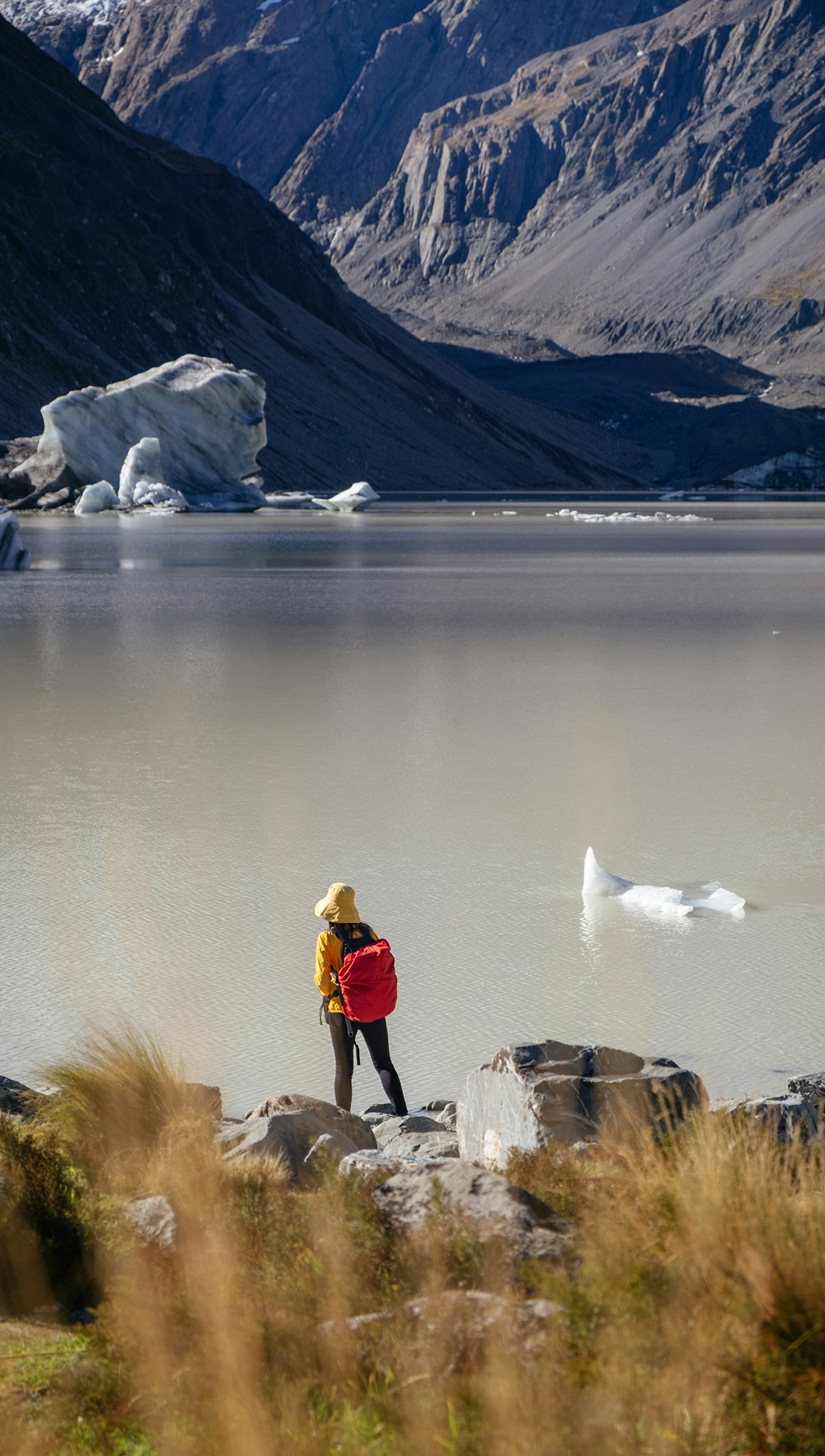 Traveller beside a mountain lake in New Zealand