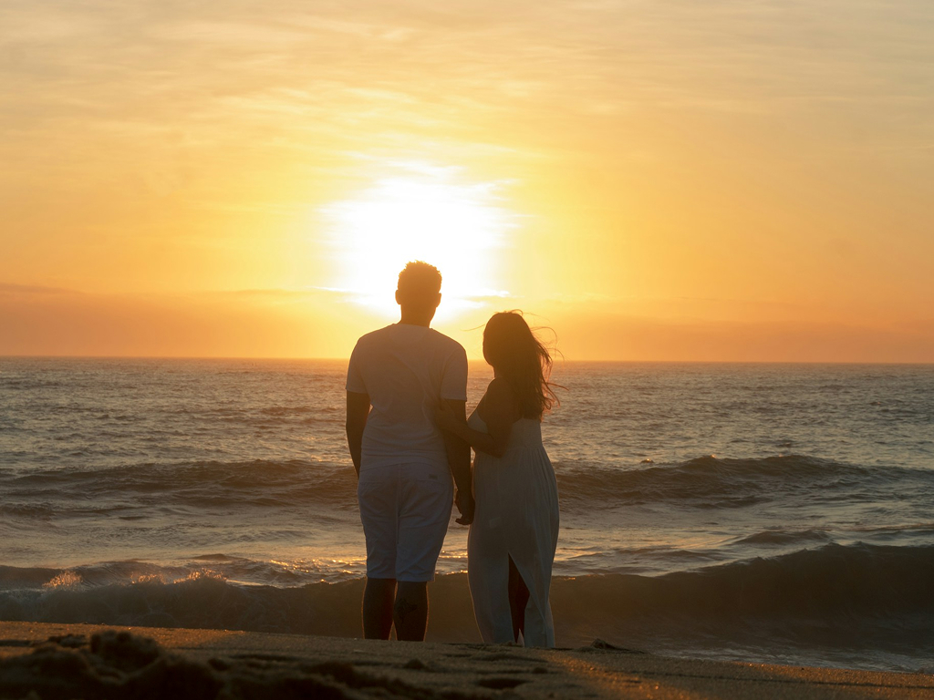 Couple enjoying a sunset by the sea
